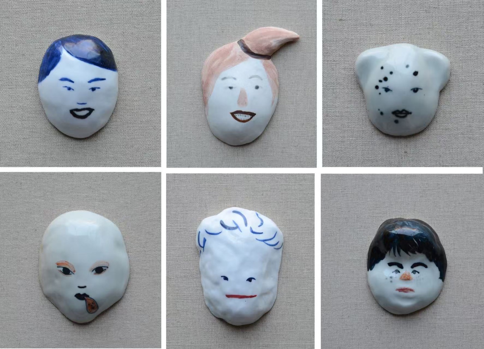Deng Ying six ceramic face objects on linen.
